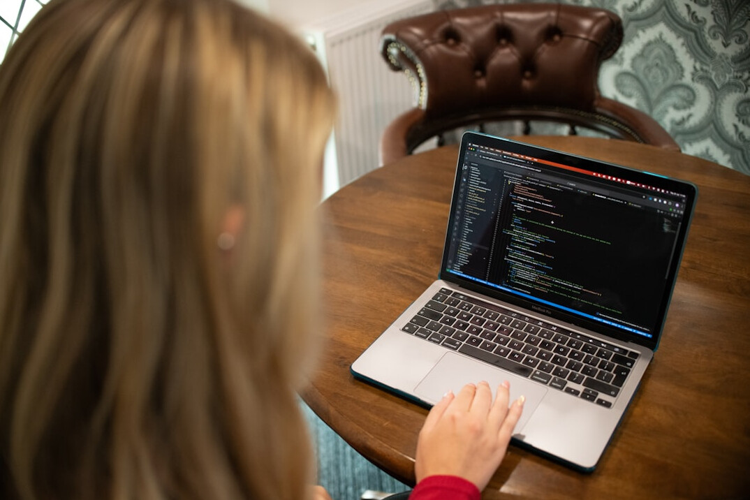 person coding at laptop